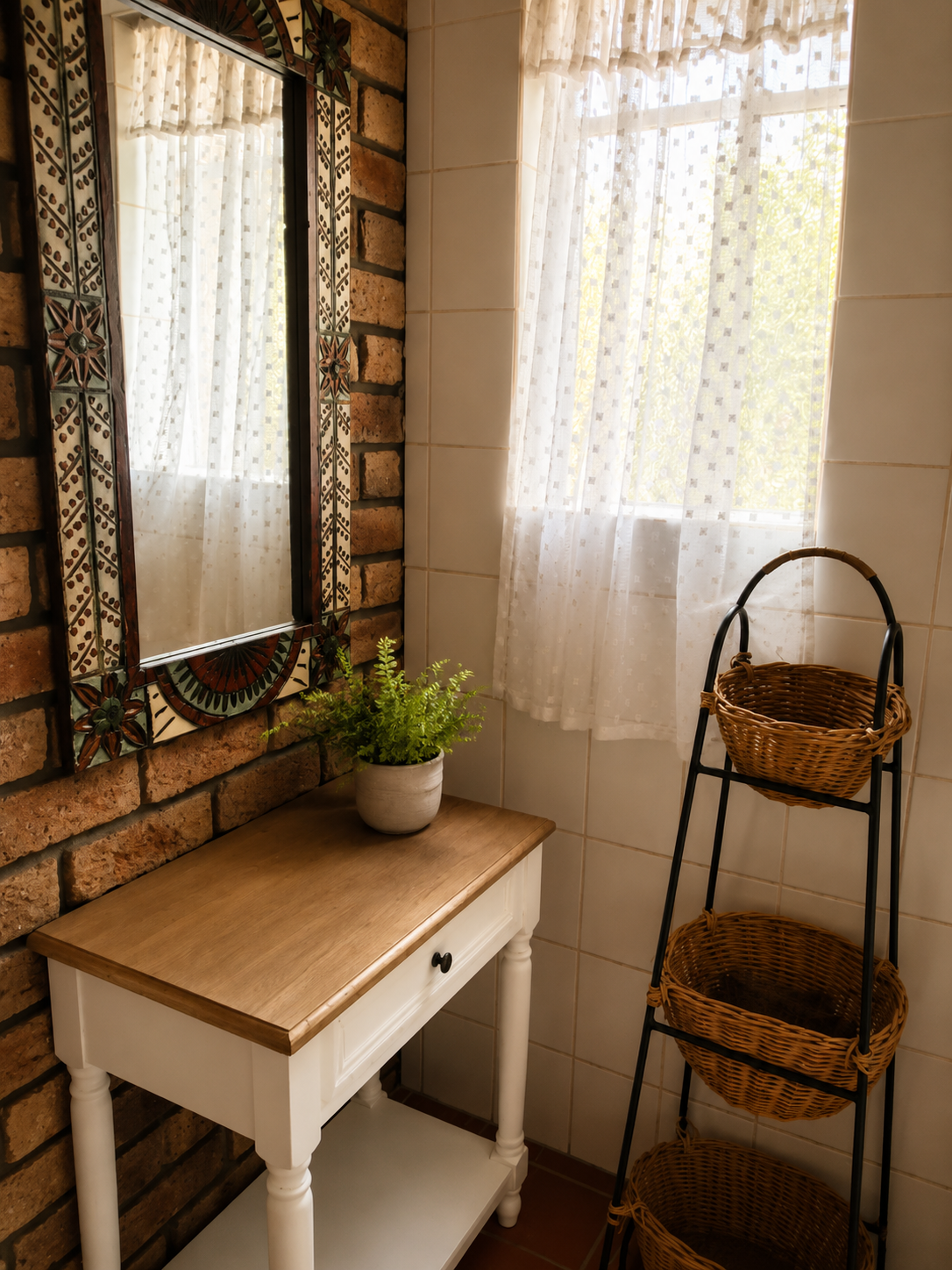 Bathroom vanity detail in the Protea Suite with decorative mirror, soft curtains and woven storage baskets